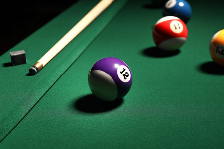 Different billiard balls with cue on green tableの写真素材