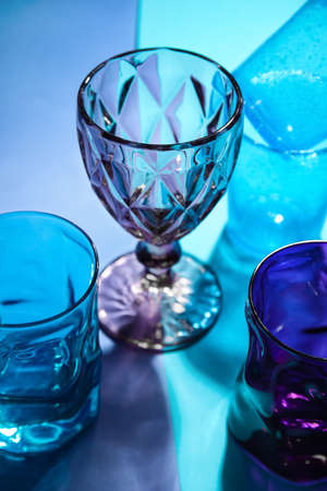 Stylish empty glasses on color background, closeupの写真素材