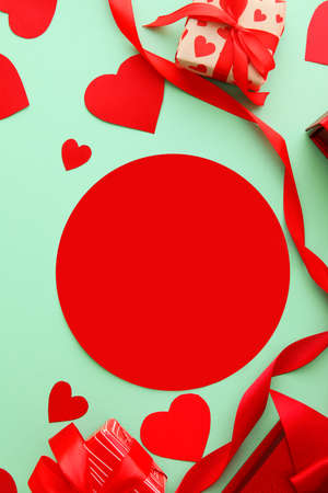 Composition with blank card, paper hearts and gift boxes on color background, closeup. Valentine's Day celebrationの写真素材