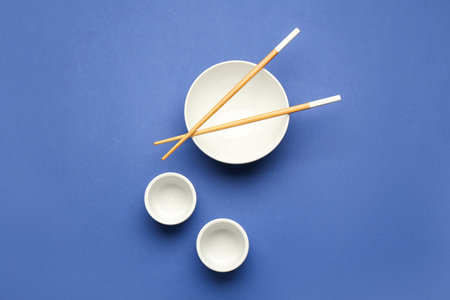 Chinese bowls with chopsticks on color backgroundの写真素材