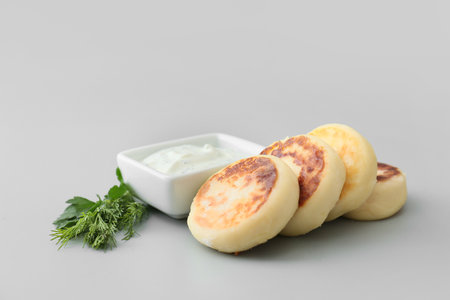 Tasty cottage cheese pancakes and sauce on gray backgroundの写真素材