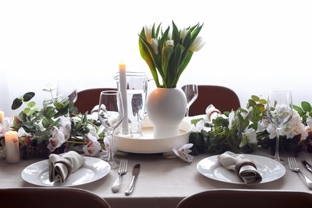 Stylish table setting with tulip flowers in dining room