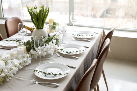 Dining table with beautiful setting, flowers and blank cardsの写真素材