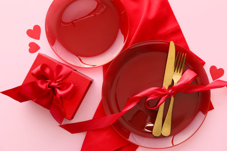Beautiful table setting for Valentine's Day and gift box on pink backgroundの写真素材