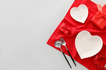 Beautiful table setting for Valentine's Day and gift boxes on light background