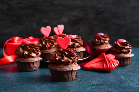 Tasty chocolate cupcakes for Valentine's day on dark background