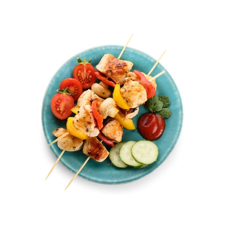 Plate of grilled chicken skewers with vegetables isolated on white backgroundの写真素材