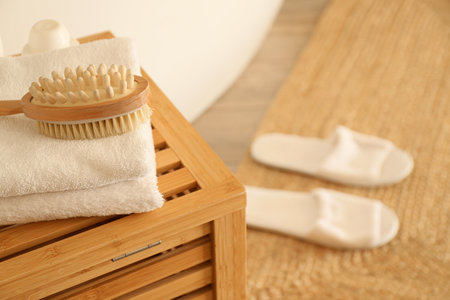 Massage brush with clean towels on chest of drawers in bathroom, closeupの写真素材