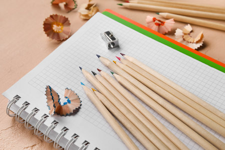 Colorful pencils, sharpener and shavings on beige backgroundの写真素材