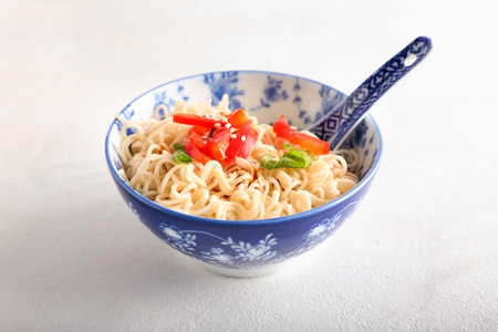 Bowl of tasty noodles on light background
