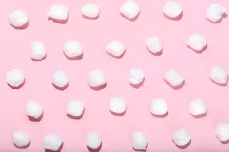 Many cotton balls on pink backgroundの写真素材
