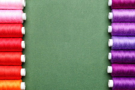 Different sewing threads on green background