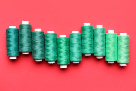 Different sewing threads on red background