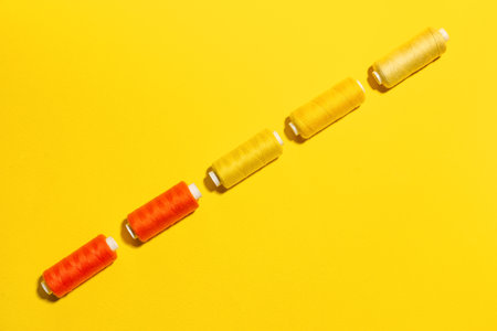 Different sewing threads on yellow background