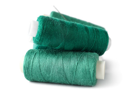 Green sewing threads on light background