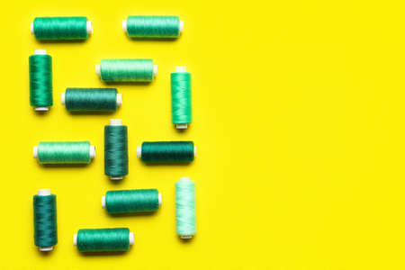 Different sewing threads on yellow backgroundの写真素材