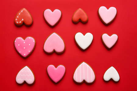 Tasty heart shaped cookies on red background