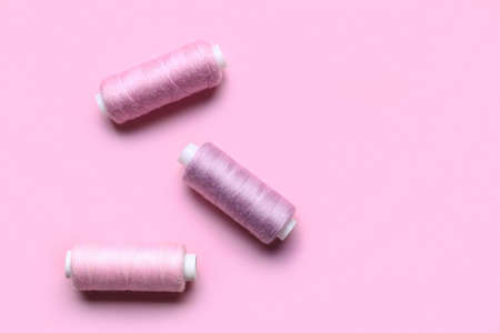 Different sewing threads on pink backgroundの写真素材