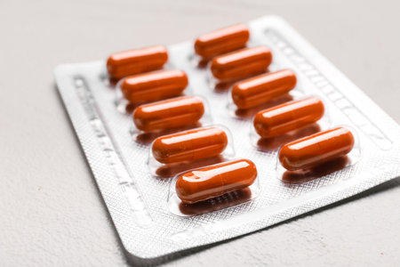 Blister pack with turmeric powder capsules on white background, closeup