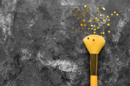Makeup brush with glitter on dark backgroundの写真素材