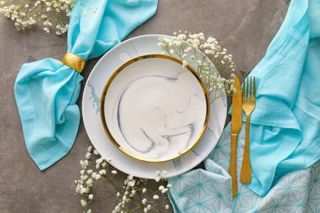 Stylish table setting with flowers on gray grunge background