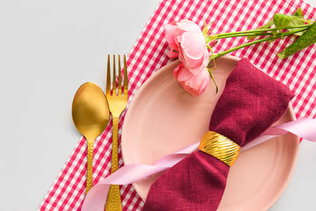 Stylish table setting with flowers on light background