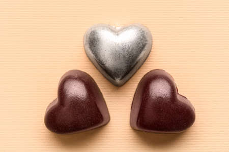 Tasty heart-shaped candies on beige background