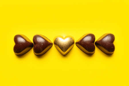 Tasty heart-shaped candies on yellow backgroundの写真素材