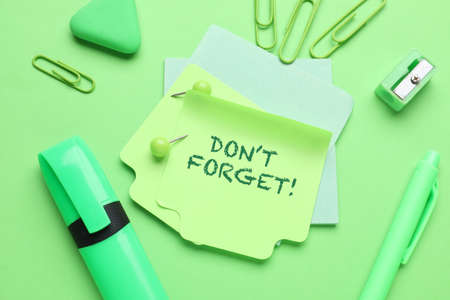 Paper with text DON'T FORGET and stationery on green backgroundの写真素材