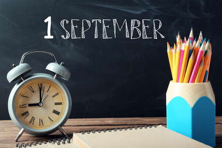 Set of school stationery and clock on table in classroom. Time to studyの写真素材