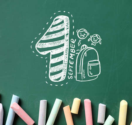 Pieces of colorful chalk and drawing on school blackboard, top viewの写真素材