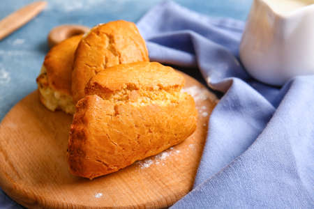 Wooden board of tasty sochniki with cottage cheese on tableの写真素材