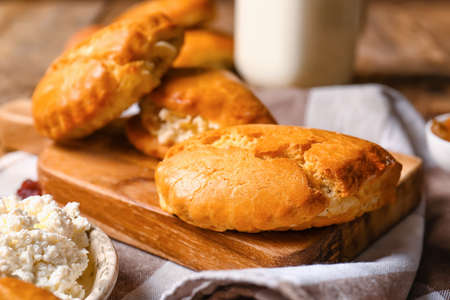 Board of tasty sochniki with cottage cheese on wooden backgroundの写真素材