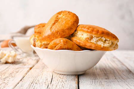 Bowl of tasty sochniki with cottage cheese on tableの写真素材