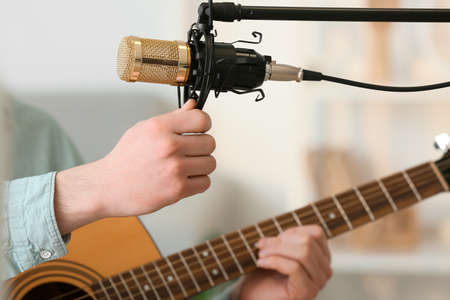 Guitar player working with microphone at home, closeup