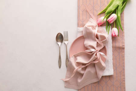Beautiful table setting with pink tulips on light backgroundの写真素材