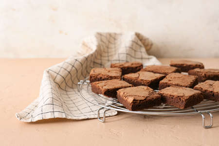 Grid with pieces of tasty chocolate brownie on beige background, closeupの写真素材
