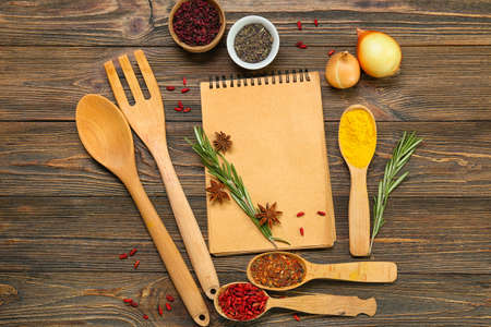 Composition with kitchen utensils, spices and notebook on wooden backgroundの写真素材