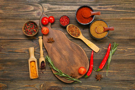 Composition with aromatic spices, vegetables and board on wooden backgroundの写真素材