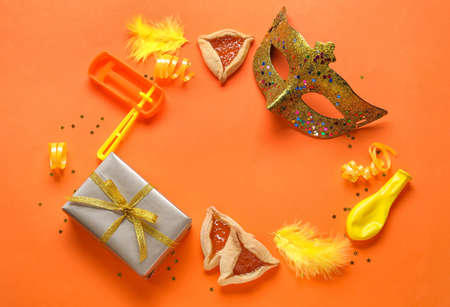 Frame made of hamantaschen and decor for Purim holiday on red backgroundの写真素材