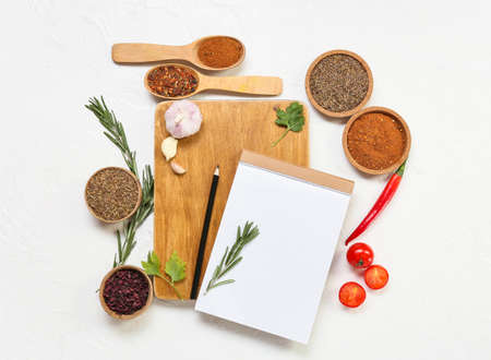 Composition with blank notebook, spices and vegetables on light backgroundの写真素材