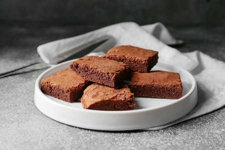Plate with pieces of tasty chocolate brownie on gray backgroundの写真素材