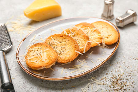 Plate of tasty croutons with cheese on gray backgroundの写真素材