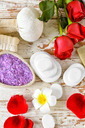 Roses, spa stones, sea salt and herbal bags on white wooden background. Valentine's Day celebrationの写真素材