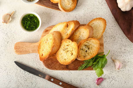 Wooden board of tasty croutons on light backgroundの写真素材