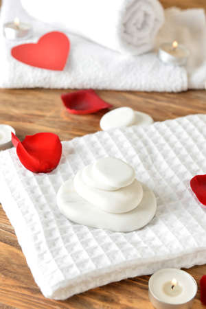 Spa stones and towels on wooden background. Valentine's Day celebrationの写真素材