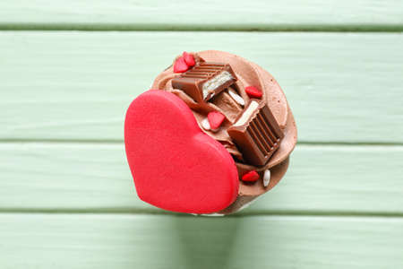 Tasty chocolate cupcake for Valentine's Day on green wooden backgroundの写真素材