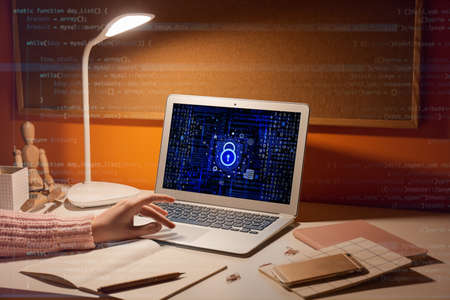 Young woman using laptop with locked screen in the evening. concept of online safety