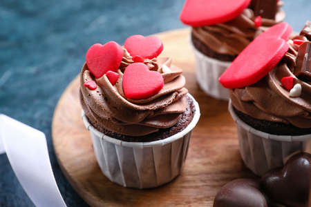 Wooden board with tasty chocolate cupcakes for Valentine's Day on black background, closeupの写真素材