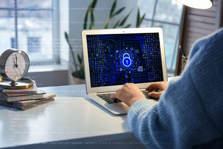 Young woman using laptop with locked screen at table. concept of online safety